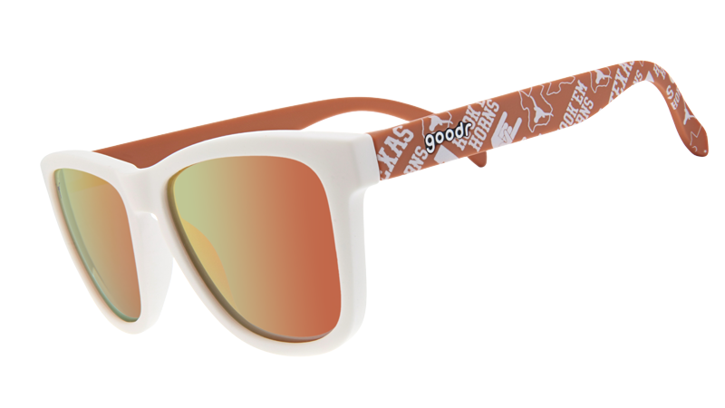 The image displays a pair of sunglasses with a white front frame and orange reflective lenses. The arms of the sunglasses are orange and decorated with University of Texas Longhorns logos